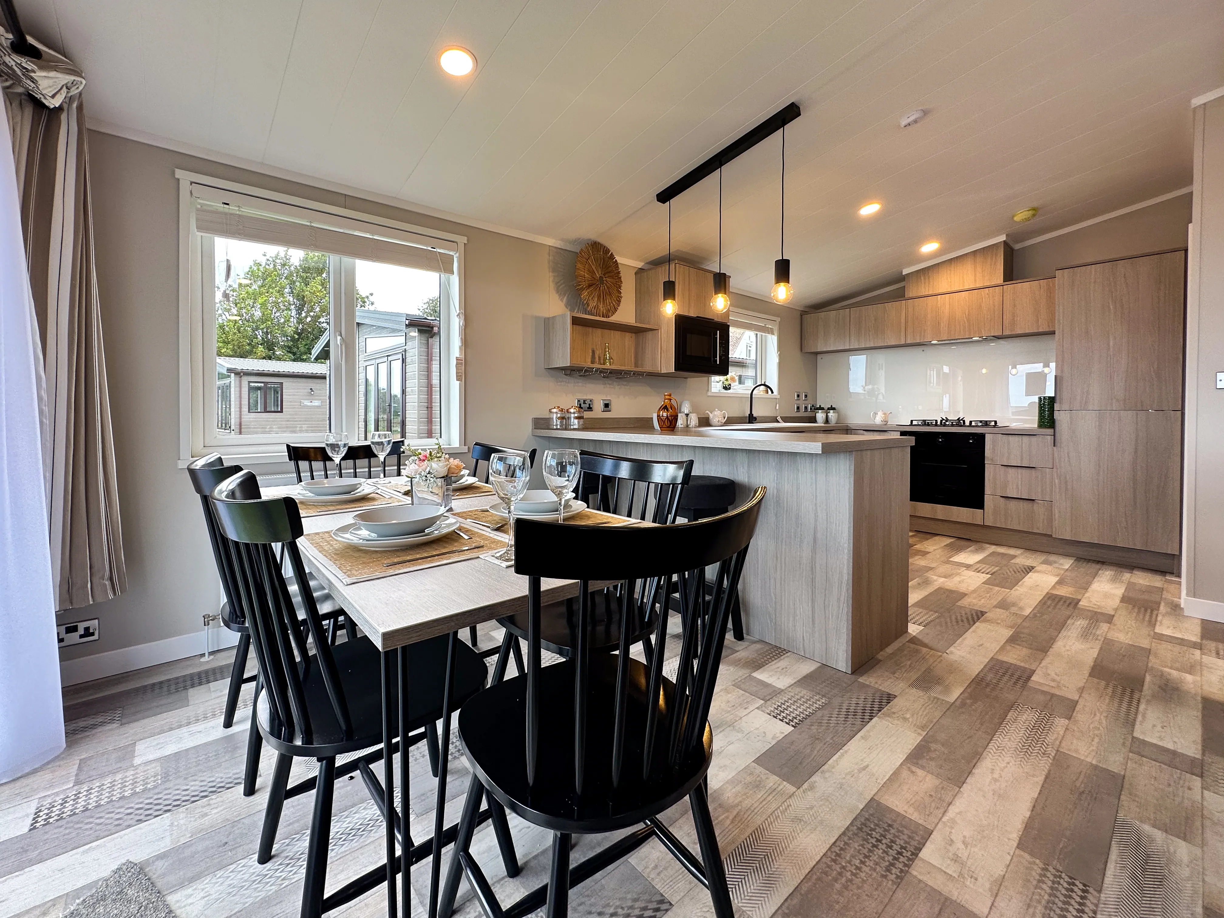 Modern open-plan kitchen and dining area with set table and pendant lights