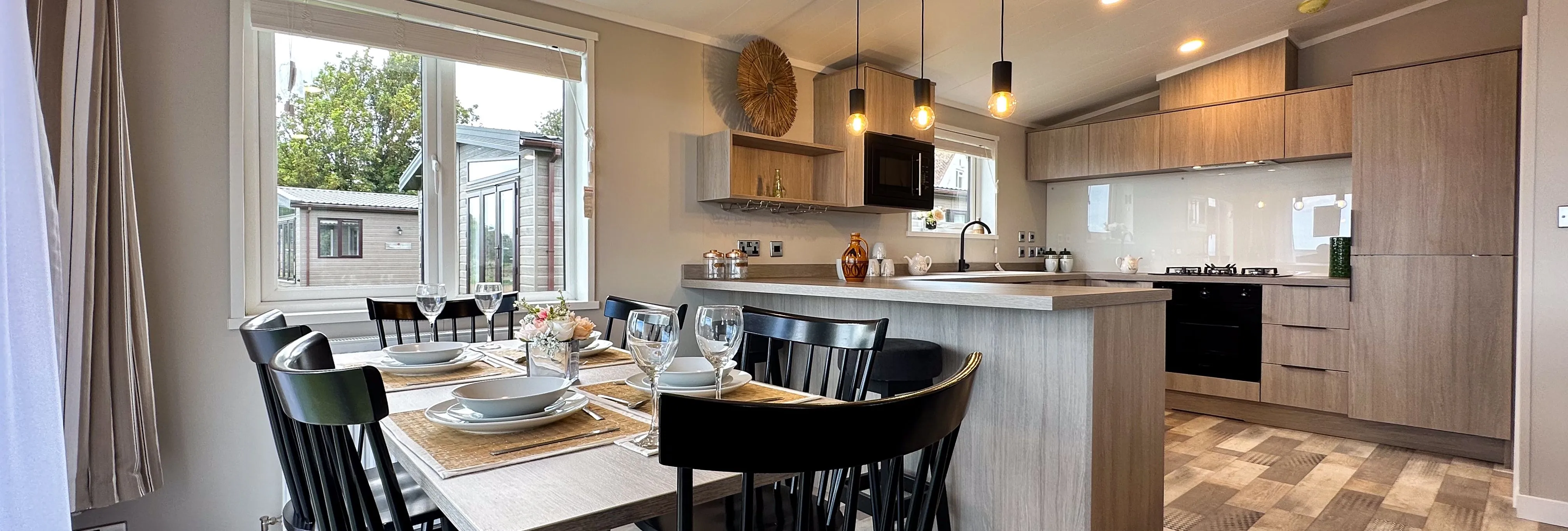 Modern open-plan kitchen and dining area with set table and pendant lights