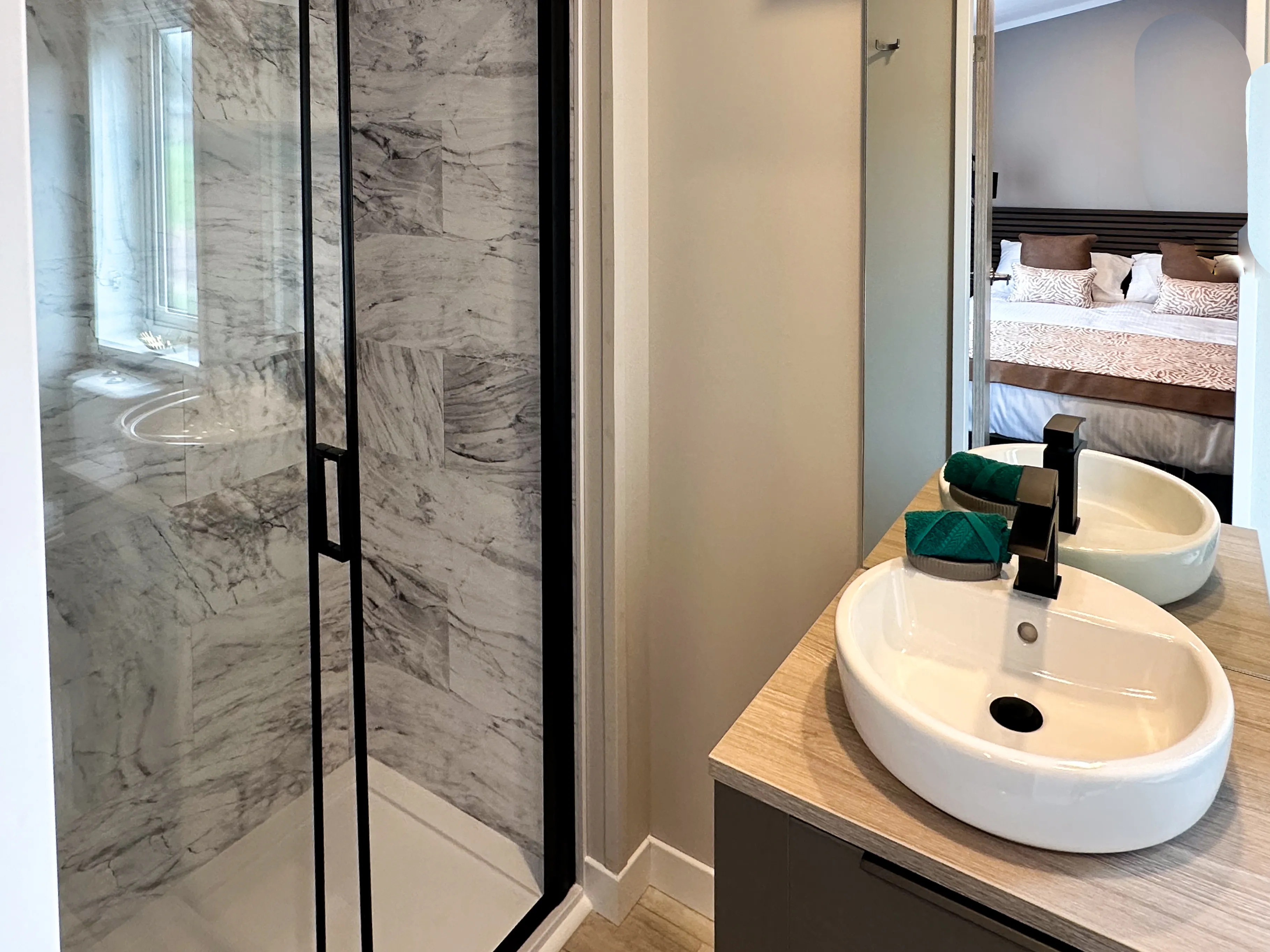 Modern bathroom with marble-tiled shower and twin vessel basins