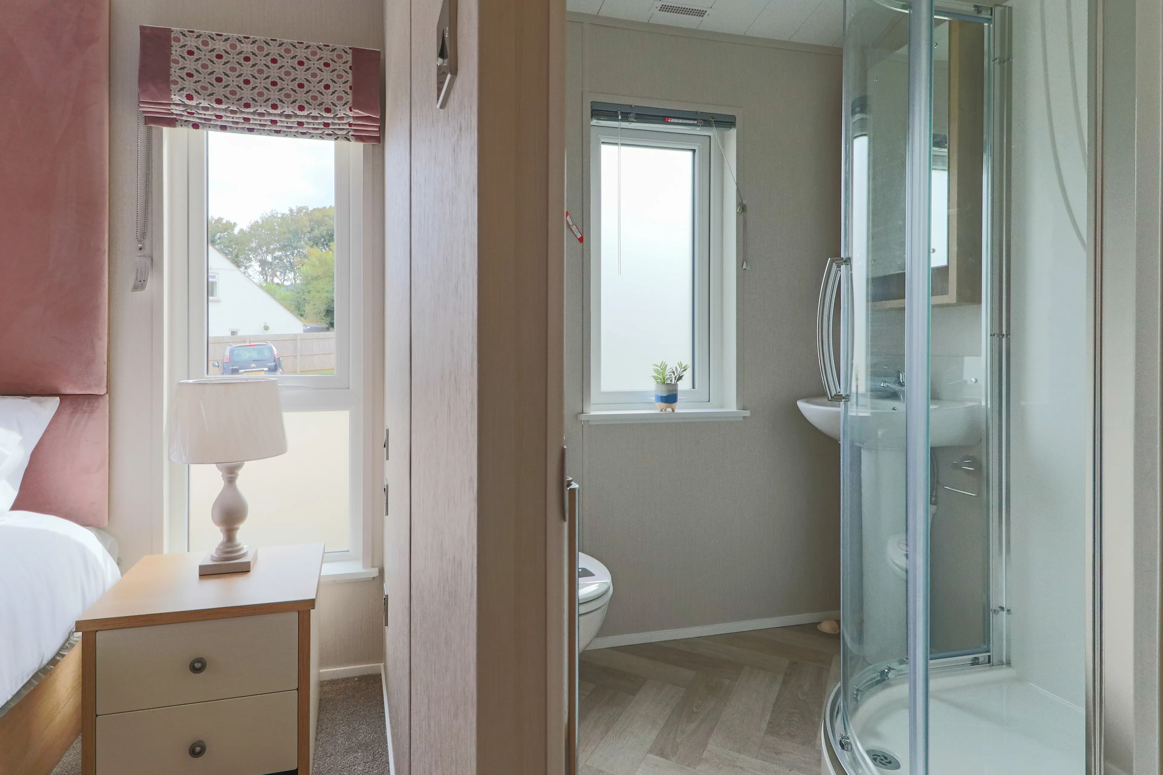 Bedroom and en-suite bathroom with bedside table, lamp, wardrobe and glass shower enclosure