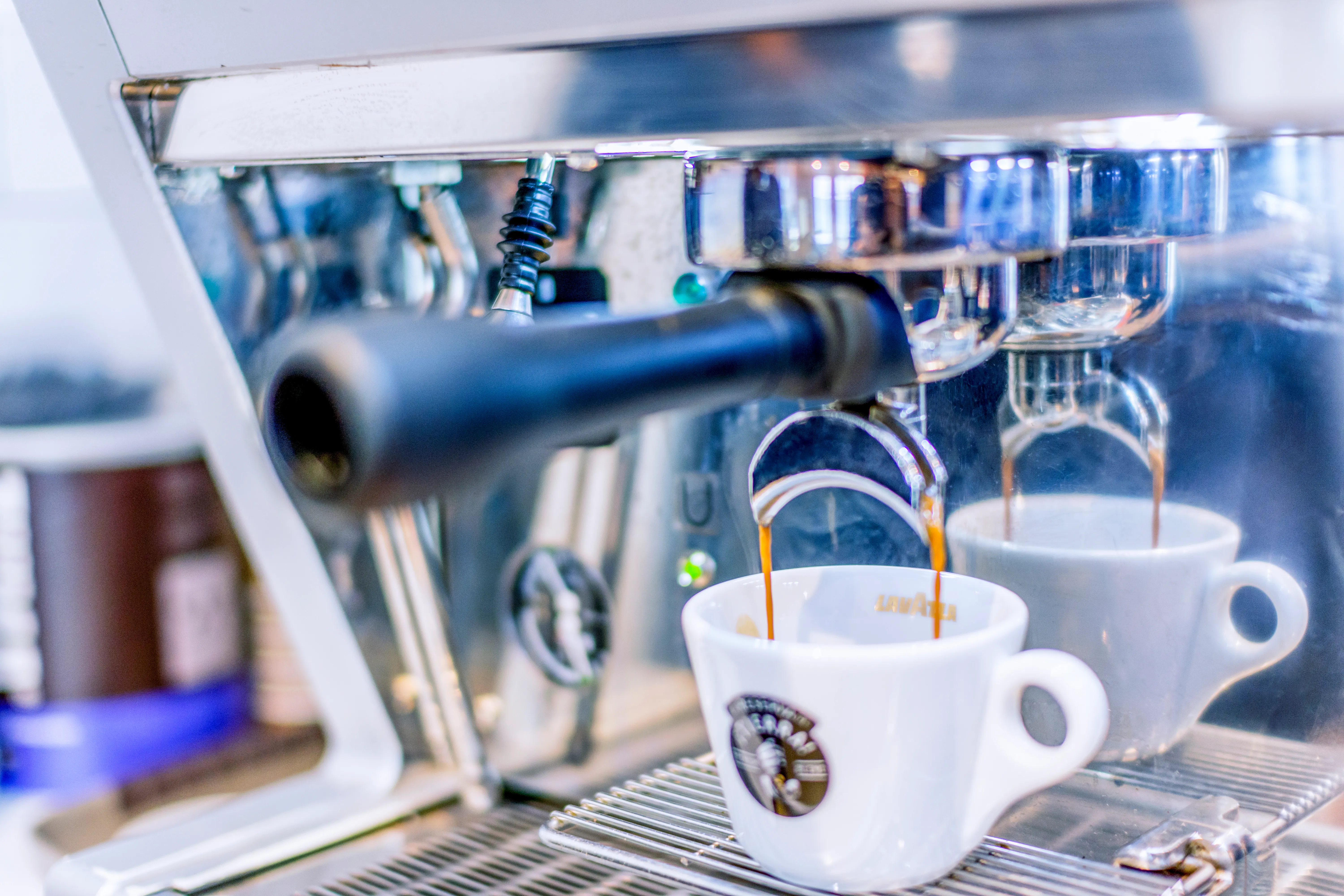 Close-up of an espresso machine pouring coffee into a white cup
