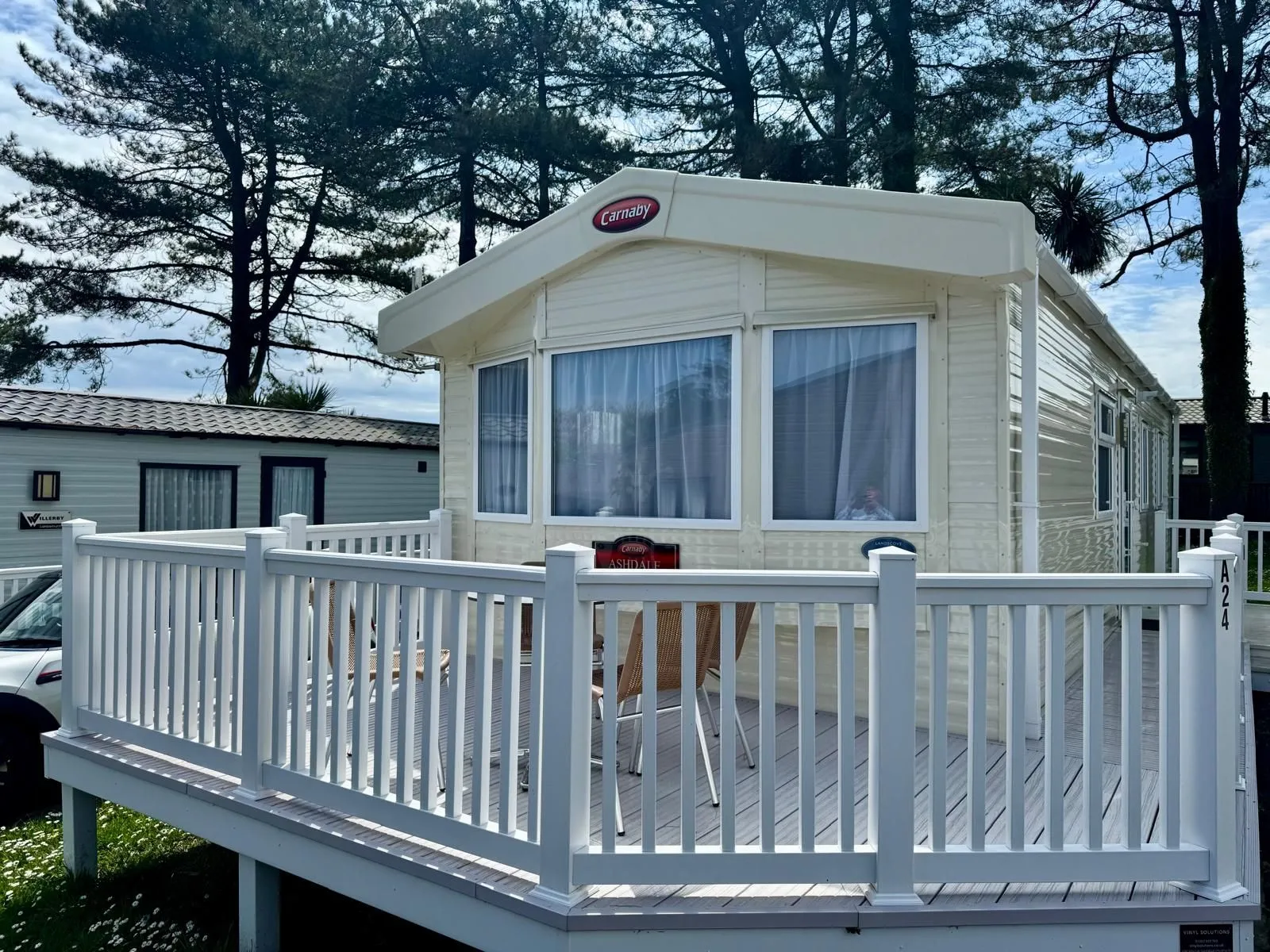 Carnaby Ashdale static caravan with a white enclosed decking area at a holiday park