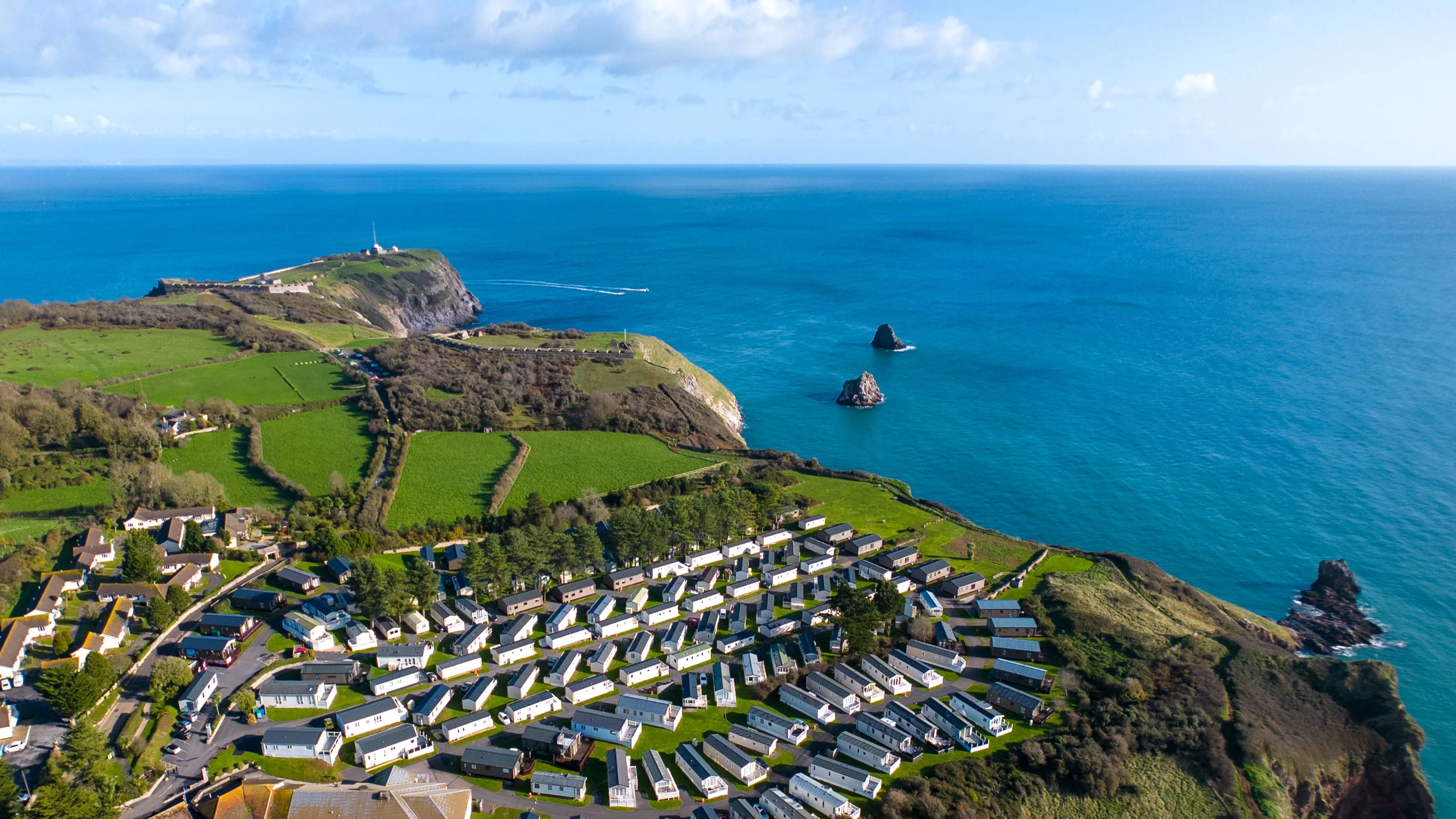 Drone view of Landscove holiday park on a clifftop coastline with turquoise sea and green fields