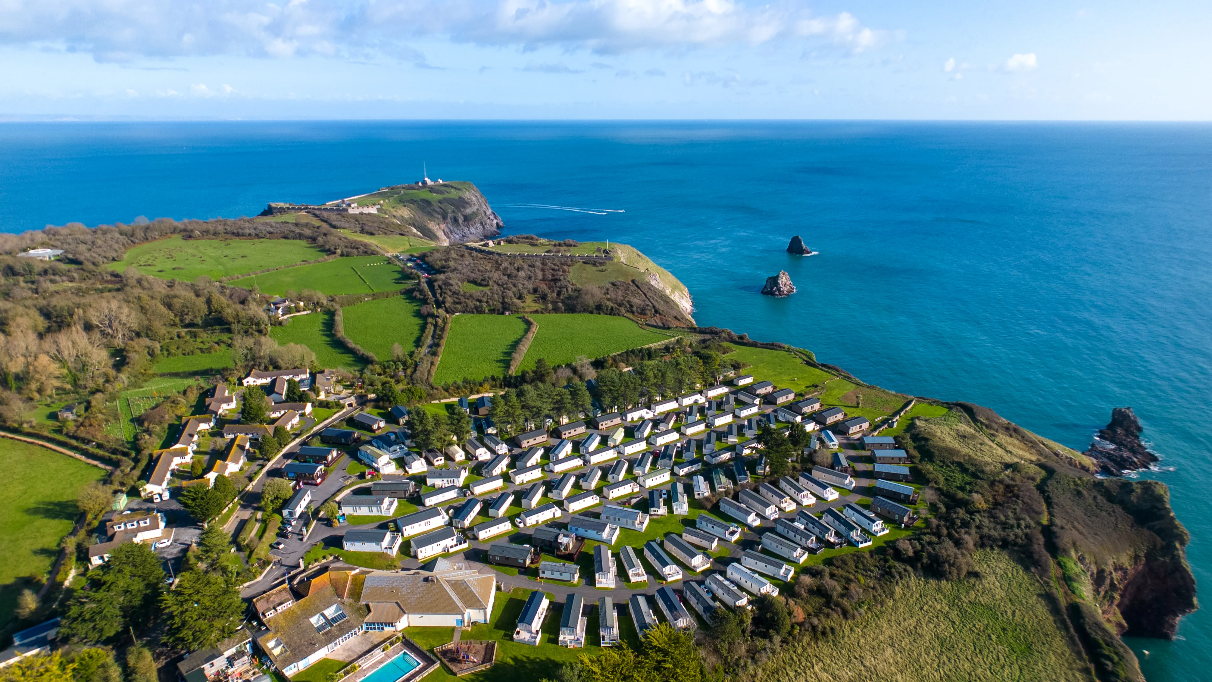 Drone view of Landscove holiday park on a clifftop coastline with turquoise sea and green fields