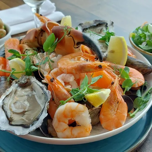 Seafood platter with prawns, oysters, mussels and crab claw, served with lemon wedges, potatoes and salad at Palmers Restaurant.