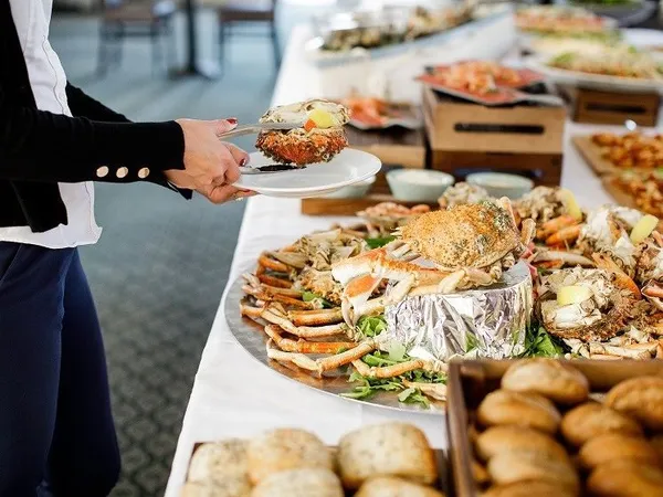 Guest serving fresh crab from a seafood buffet table at Palmers Restaurant