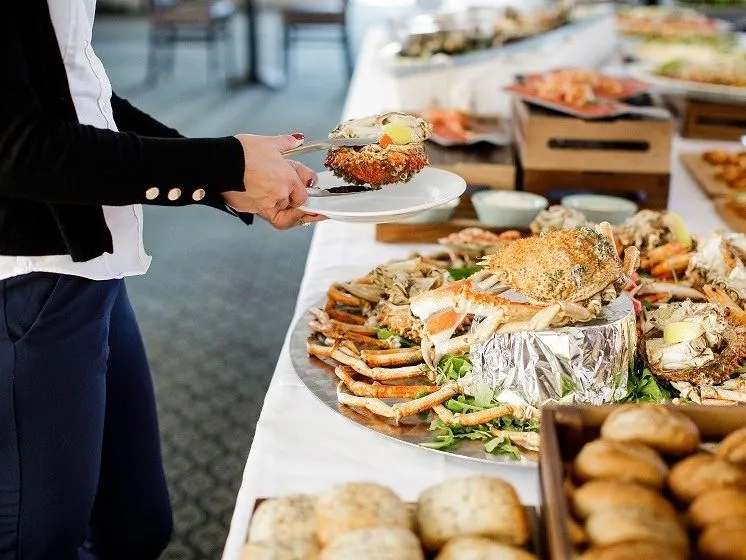 Guest serving fresh crab from a seafood buffet table at Palmers Restaurant