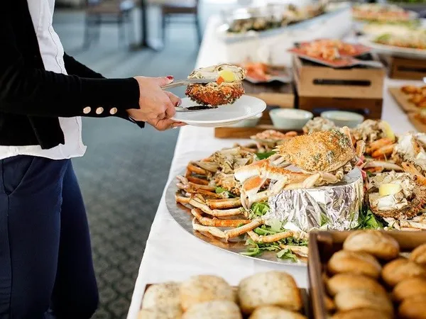 Guest serving fresh crab from a seafood buffet table at Palmers Restaurant
