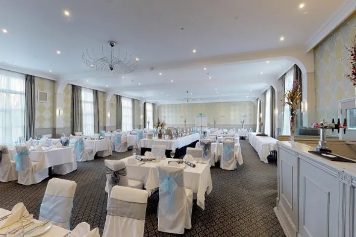 Elegant function room at Palmers Restaurant set for a formal event with white tablecloths and chair covers
