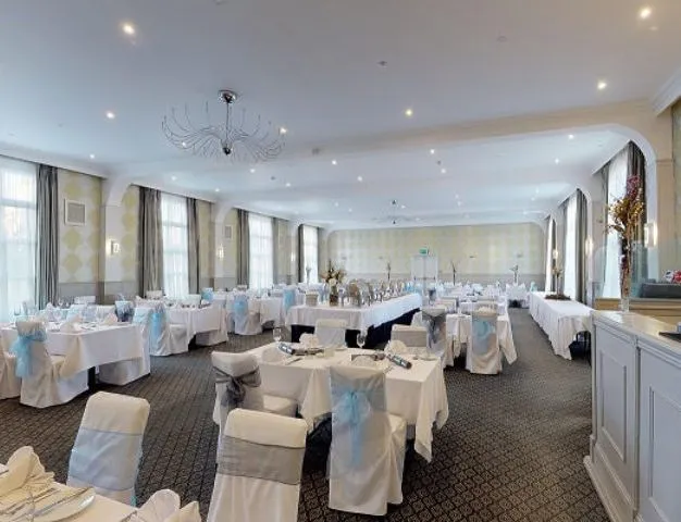 Elegant function room at Palmers Restaurant set for a formal event with white tablecloths and chair covers