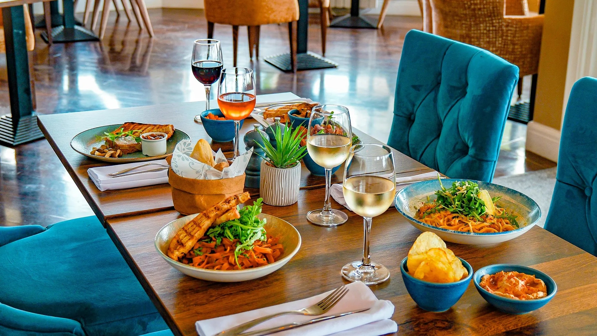 Table set with pasta dishes, wine and small plates in the Coast Bistro bar area