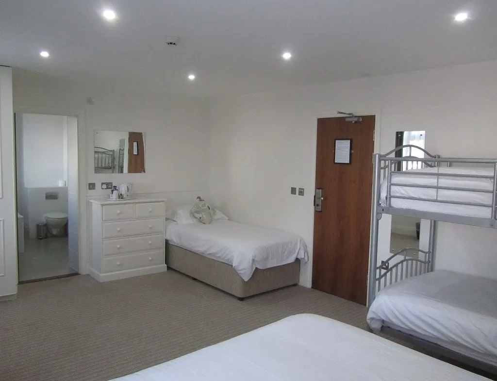 Spacious deluxe family room with a double bed, single bed, bunk beds and an en-suite bathroom