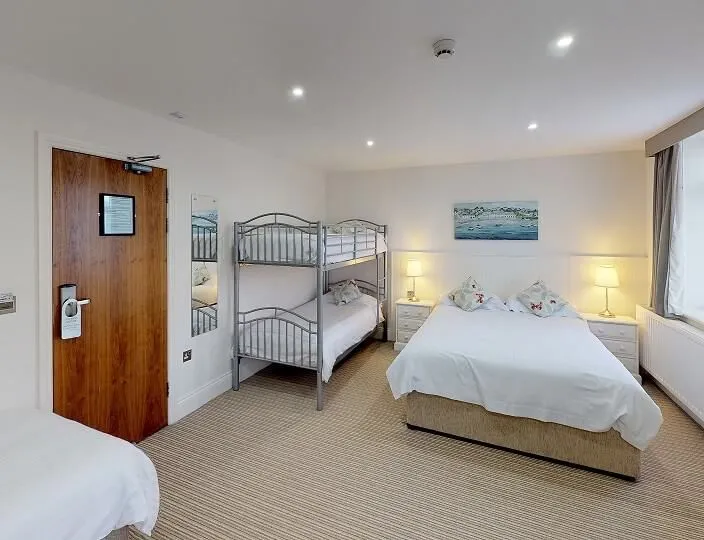 Family room for 5 with a double bed, bunk beds and a single bed in a bright, spacious bedroom