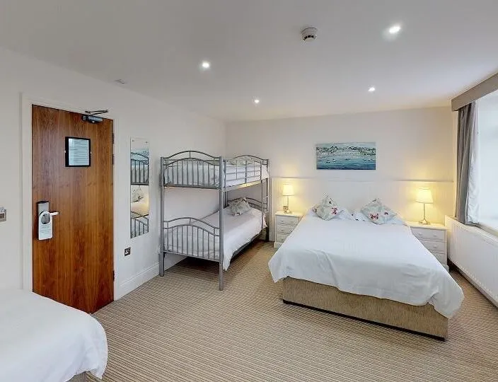 Family room for 5 with a double bed, bunk beds and a single bed in a bright, spacious bedroom