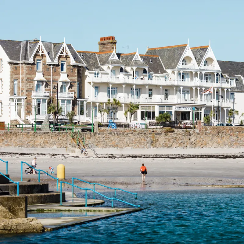 General view of Havre des Pas seafront with beachfront hotel buildings, sandy shore and sea pool steps in Jersey