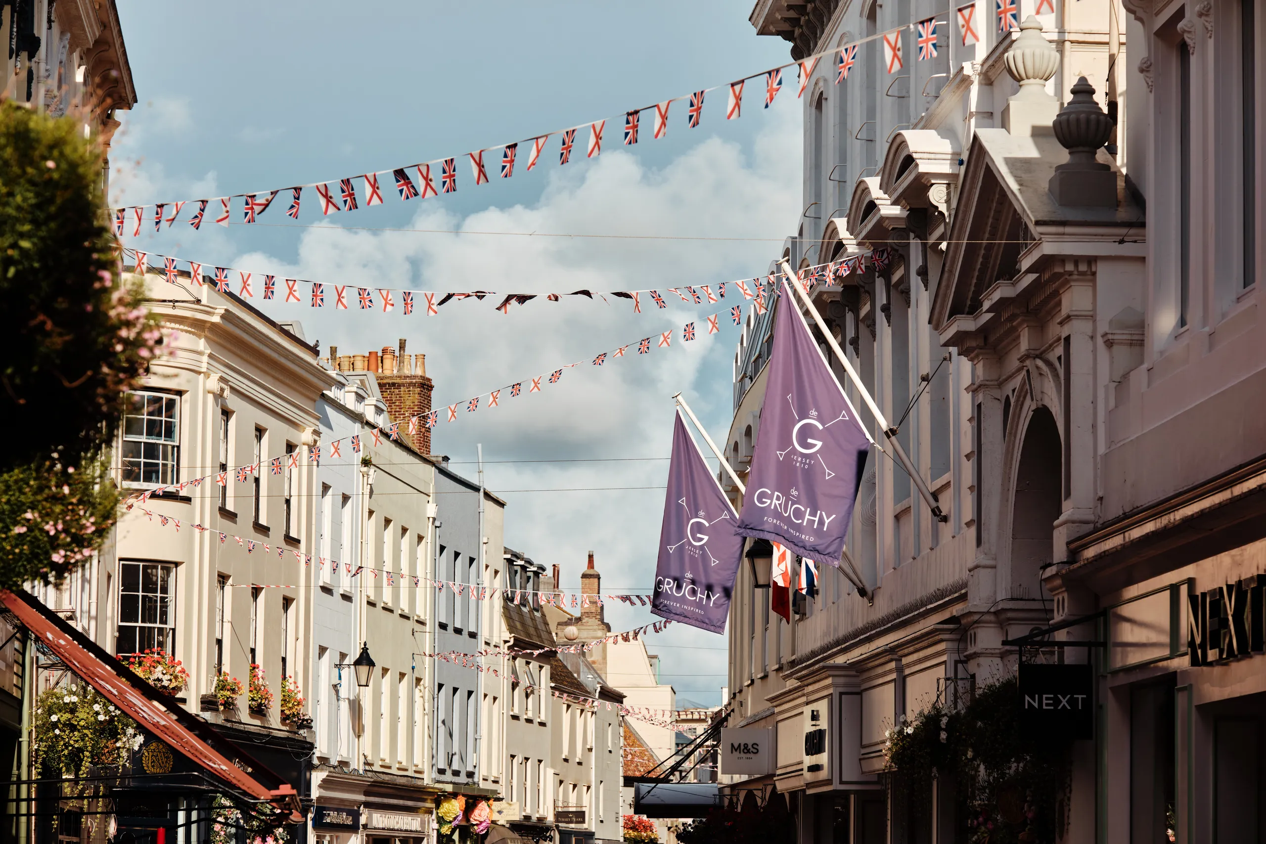 Street in Saint Helier, Jersey, decorated with Union Jack and Jersey flag bunting between historic buildings