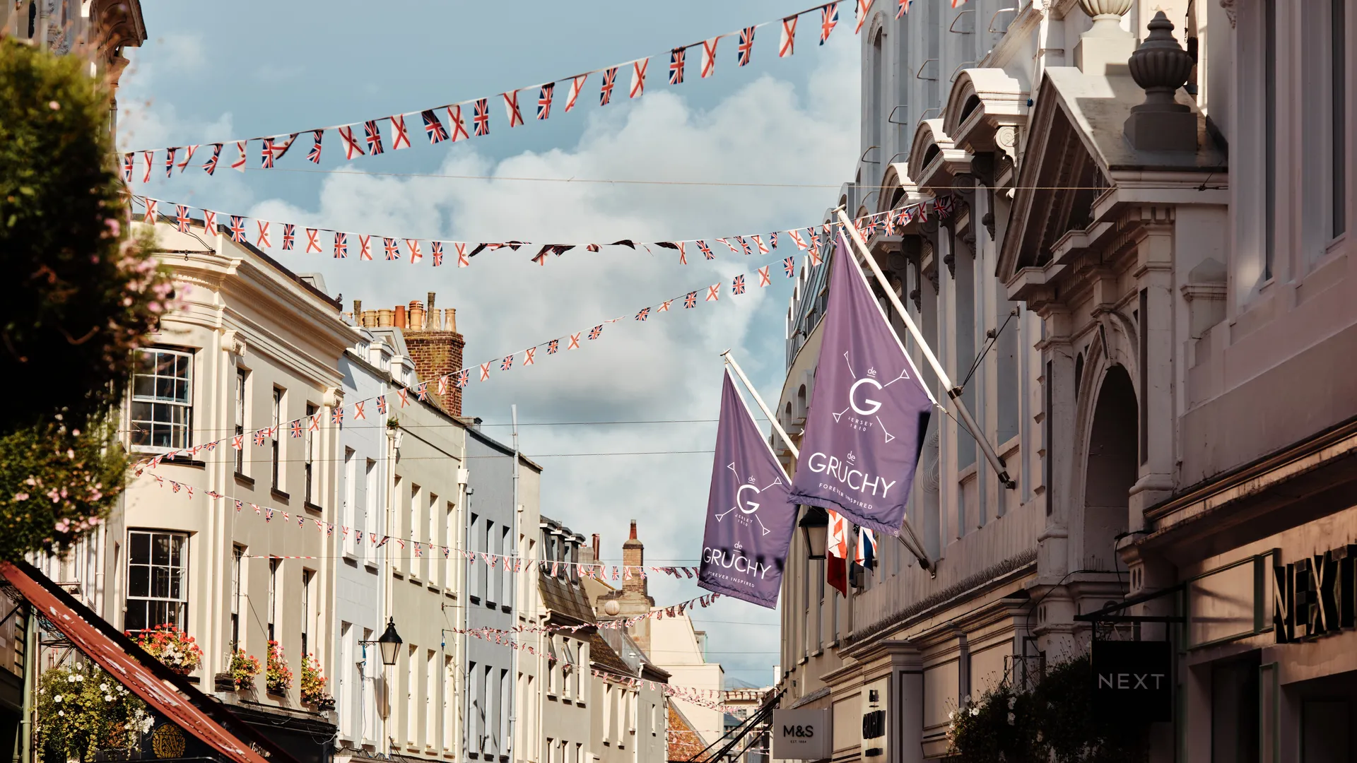 Street in Saint Helier, Jersey, decorated with Union Jack and Jersey flag bunting between historic buildings