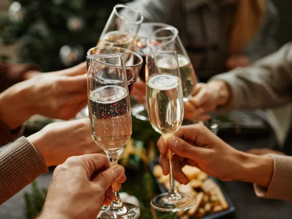 People clinking champagne flutes in a festive gathering