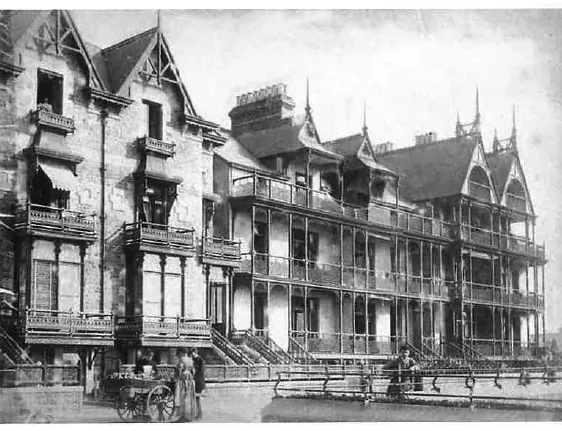 Historic black-and-white photograph of a grand Victorian hotel with gabled roofs, balconies and a covered veranda.