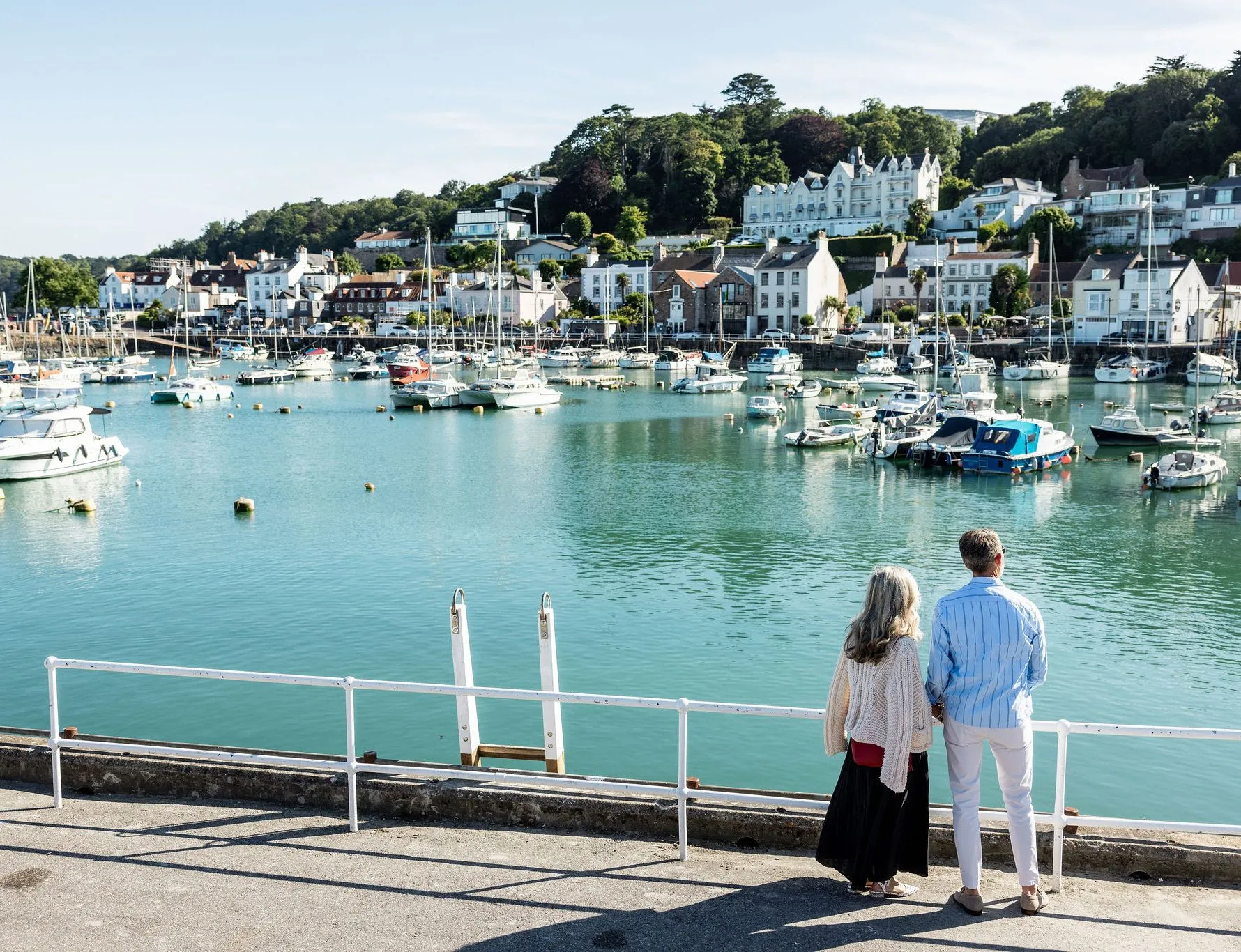 Couple overlooking the boat-filled harbour at St Aubin, Jersey