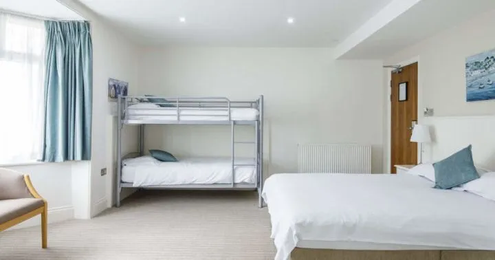 Spacious family bedroom with a double bed, bunk beds and blue curtains
