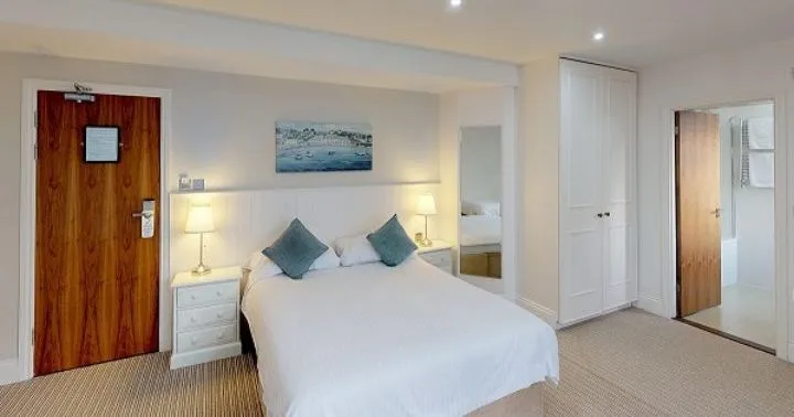 Classic hotel bedroom with a double bed, bedside tables, wardrobe and en-suite bathroom