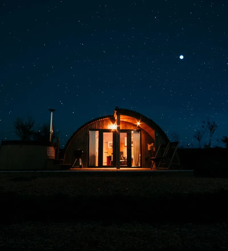 Cosy, warmly lit cabin under a starry night sky