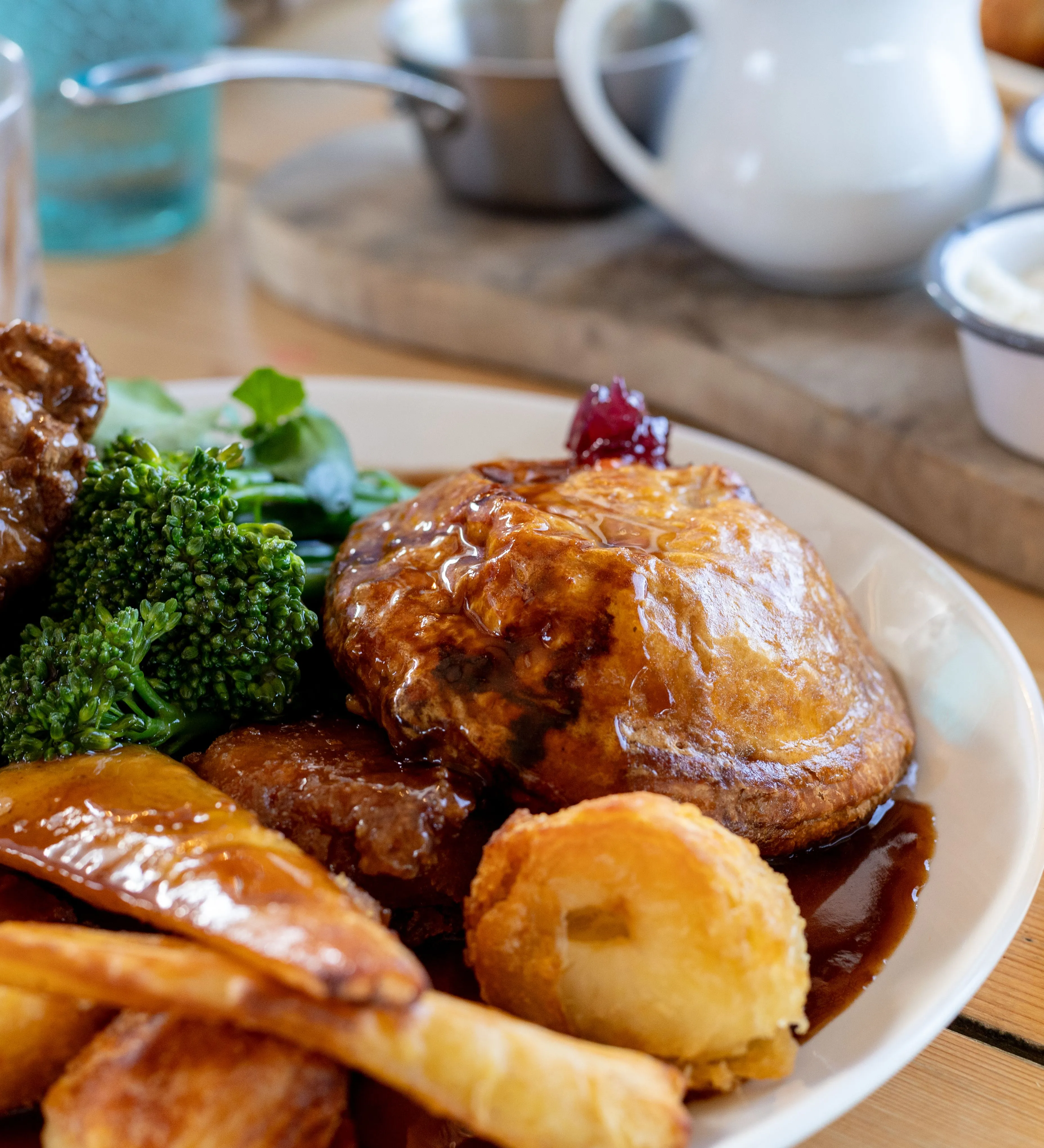 Sunday roast with Yorkshire pudding, roast potatoes, carrots, broccoli and gravy, served with a pint of lager