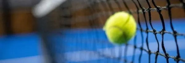 Tennis ball caught in a net on a blue court