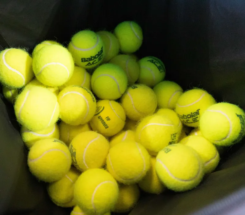 Pile of yellow tennis balls in a hopper