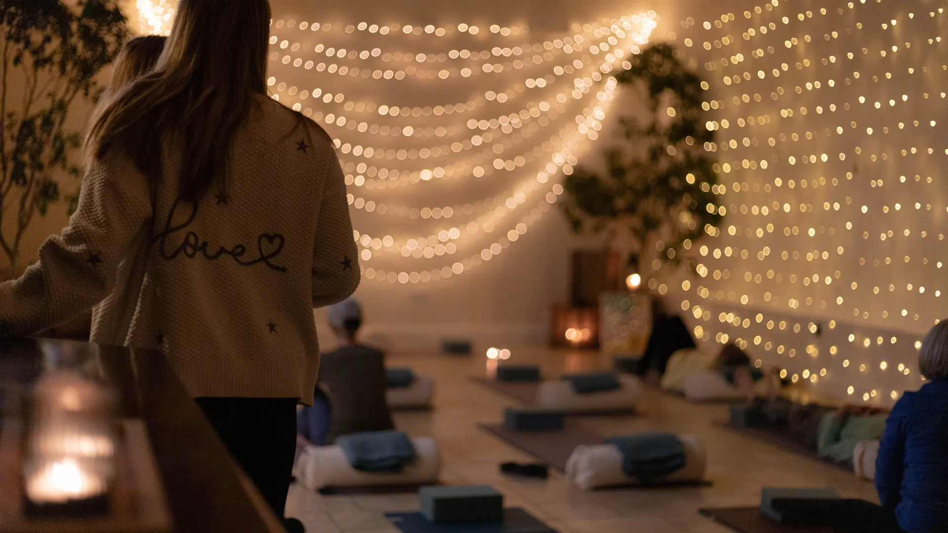 Cosy yoga studio with fairy lights and yoga mats laid out on the floor