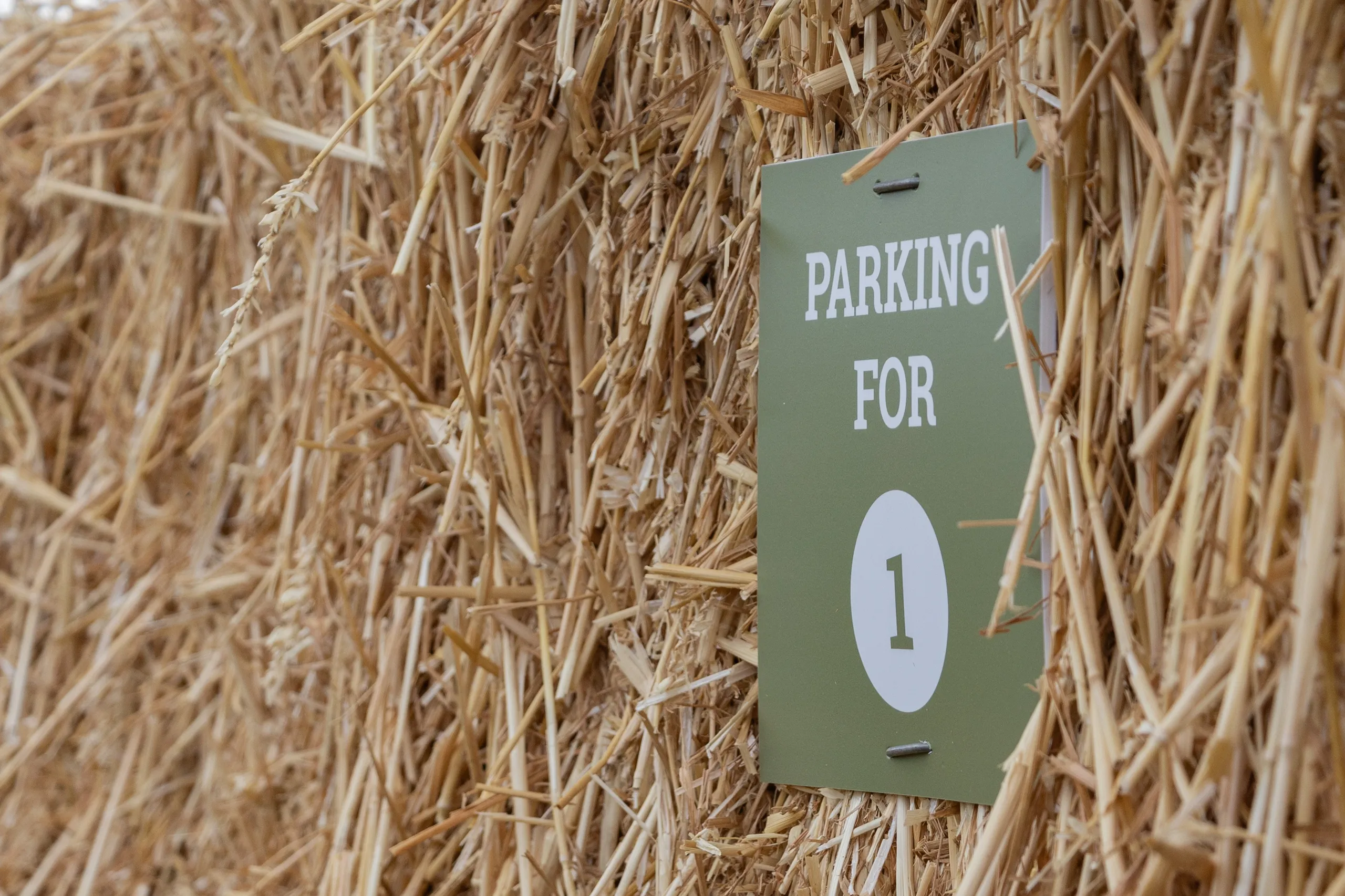 Green sign on a straw bale reading 
