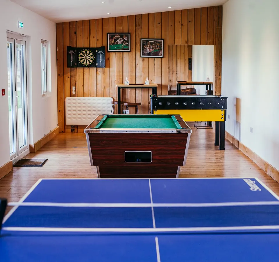 Games room with table tennis, pool table, dartboard and foosball table