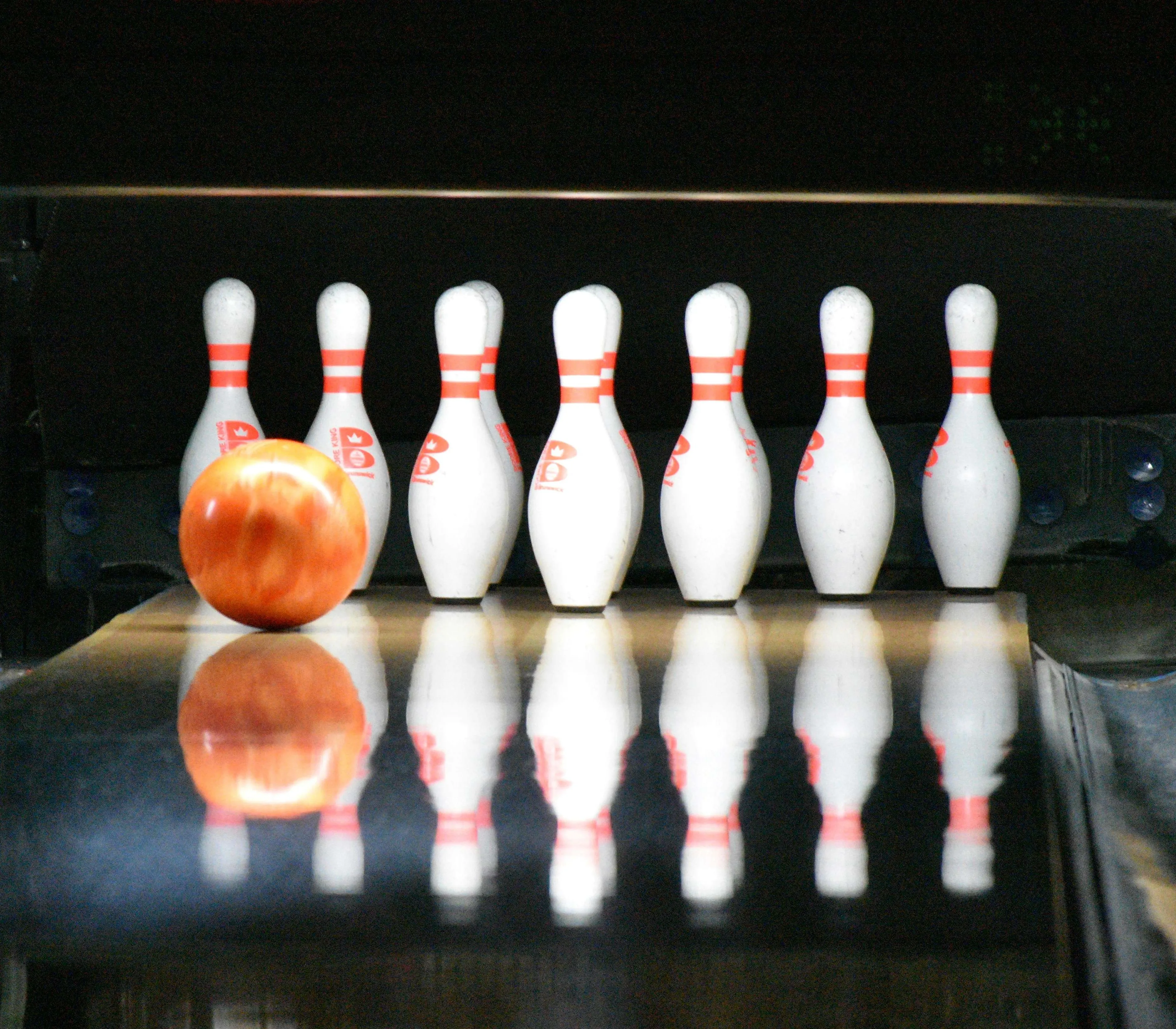 Bowling ball approaching pins on a shiny lane