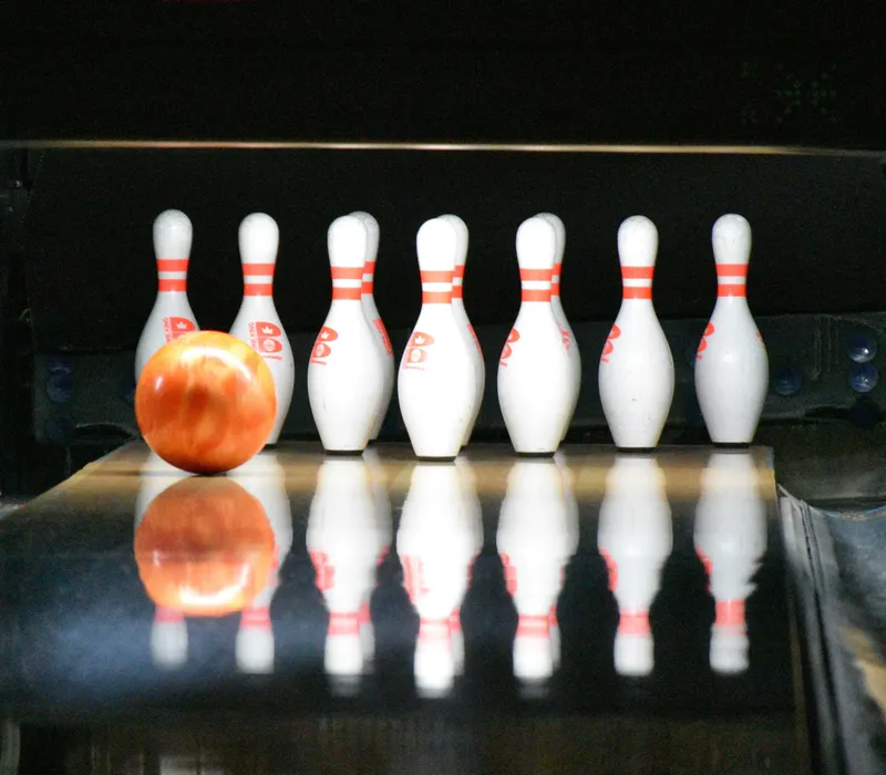Bowling ball approaching pins on a shiny lane