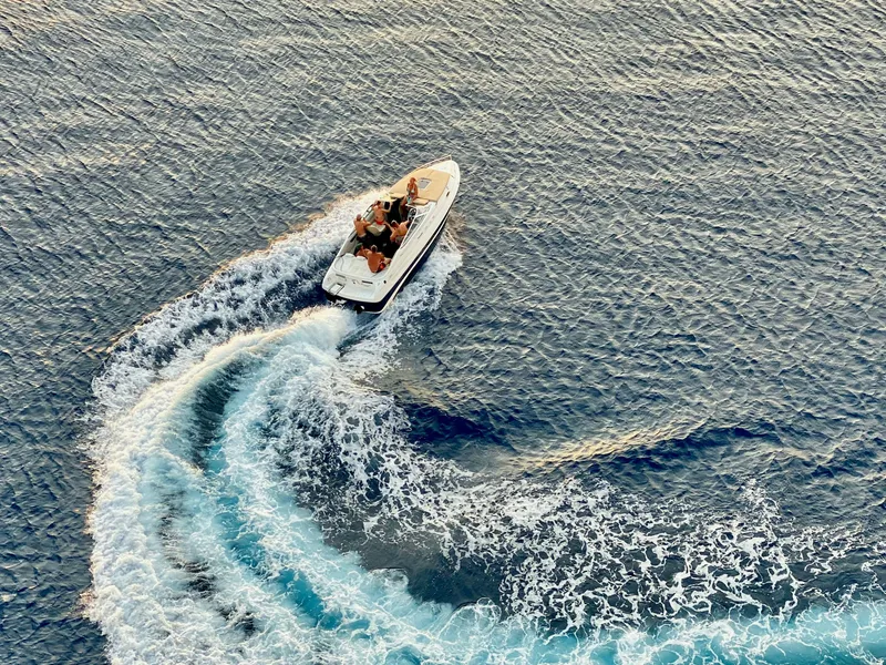 Aerial view of a speedboat turning on the sea, leaving a foamy wake behind it