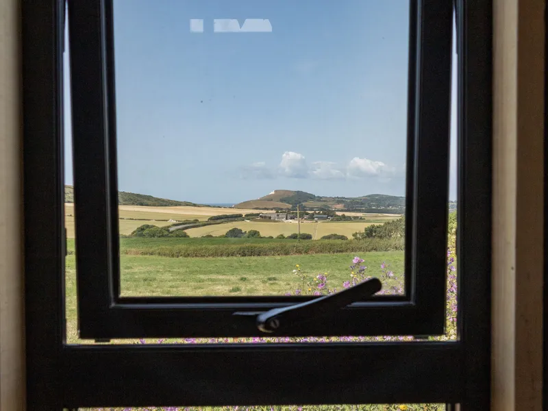 Countryside and sea view through a window at Camp Tapnell container accommodation