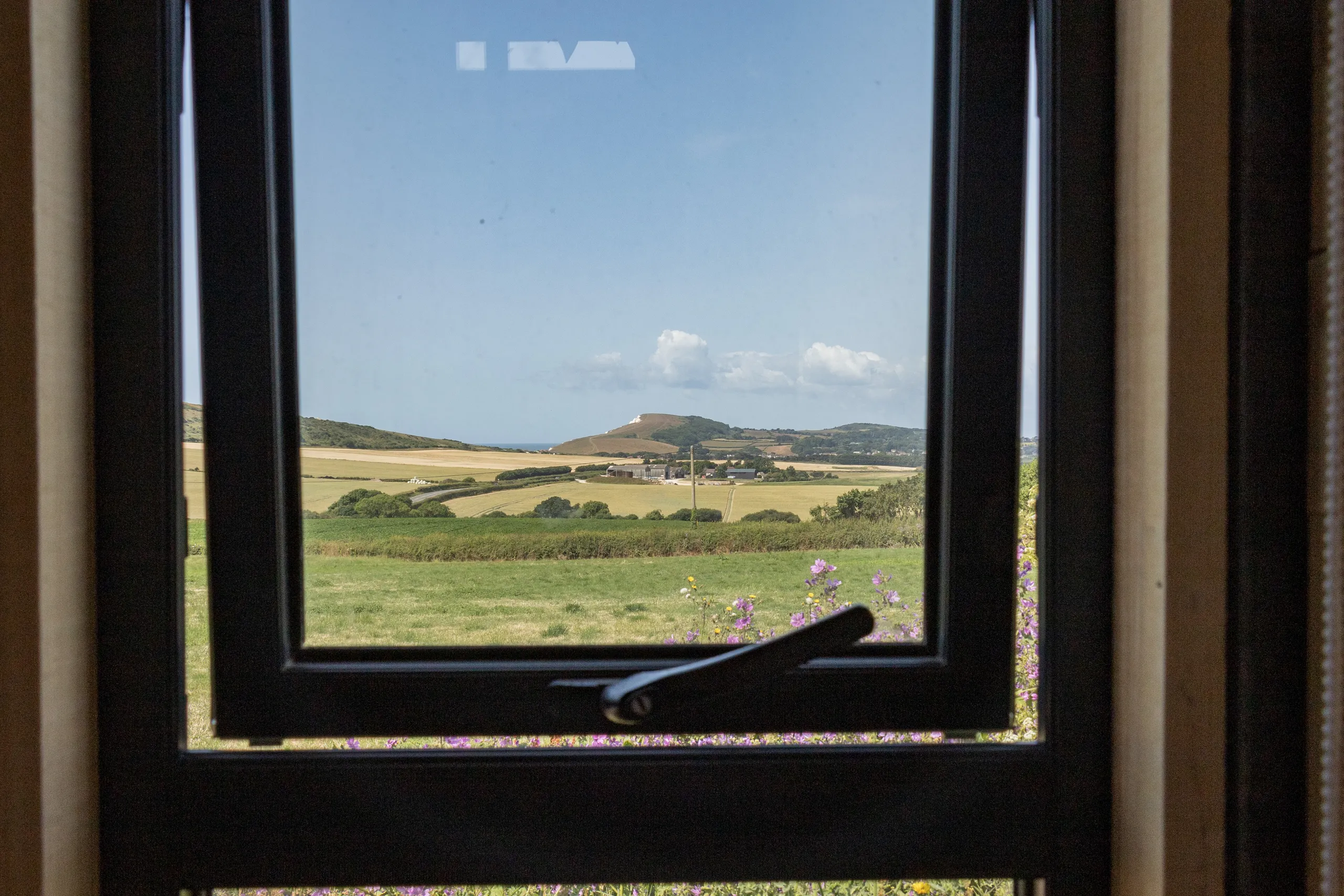 Countryside and sea view through a window at Camp Tapnell container accommodation