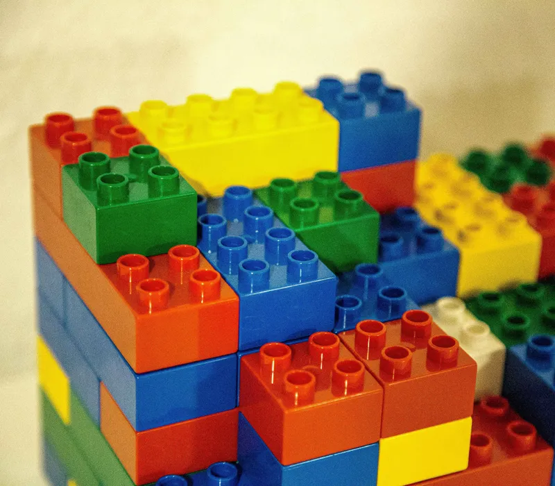 Close-up of colourful interlocking plastic building blocks stacked in a small structure