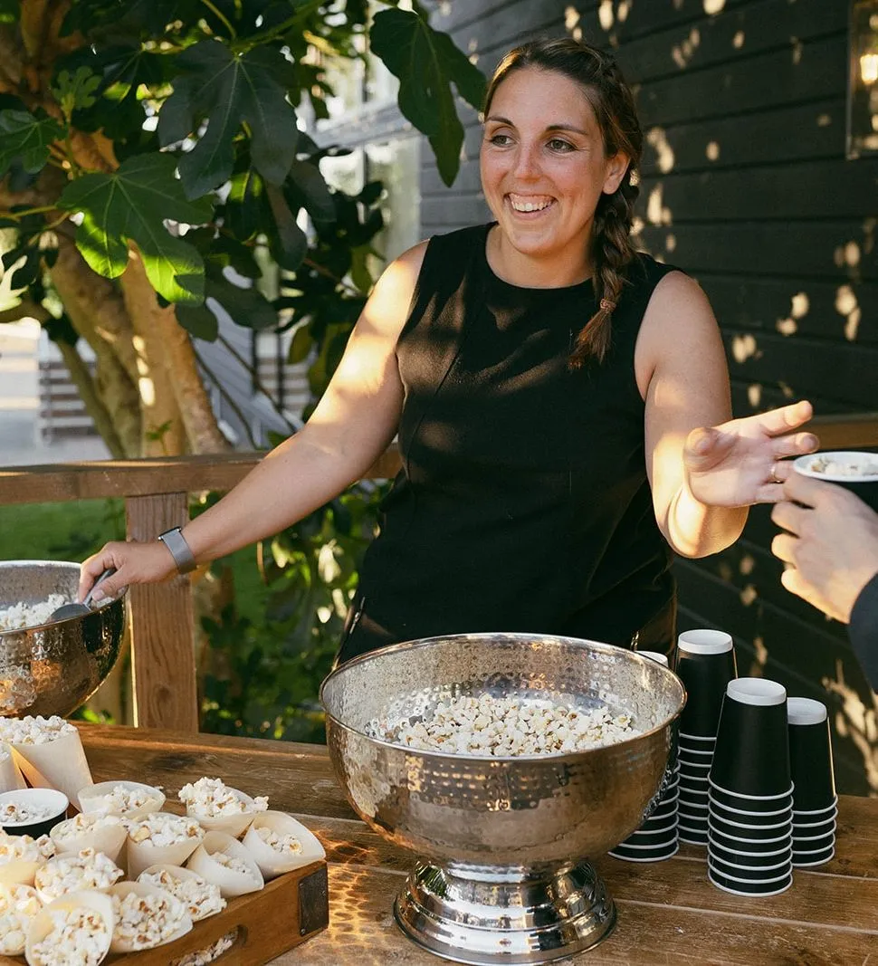 Woman serving popcorn at an outdoor refreshments table