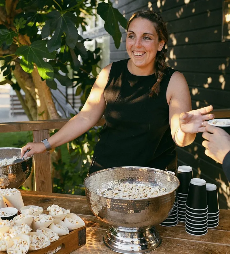Woman serving popcorn at an outdoor refreshments table
