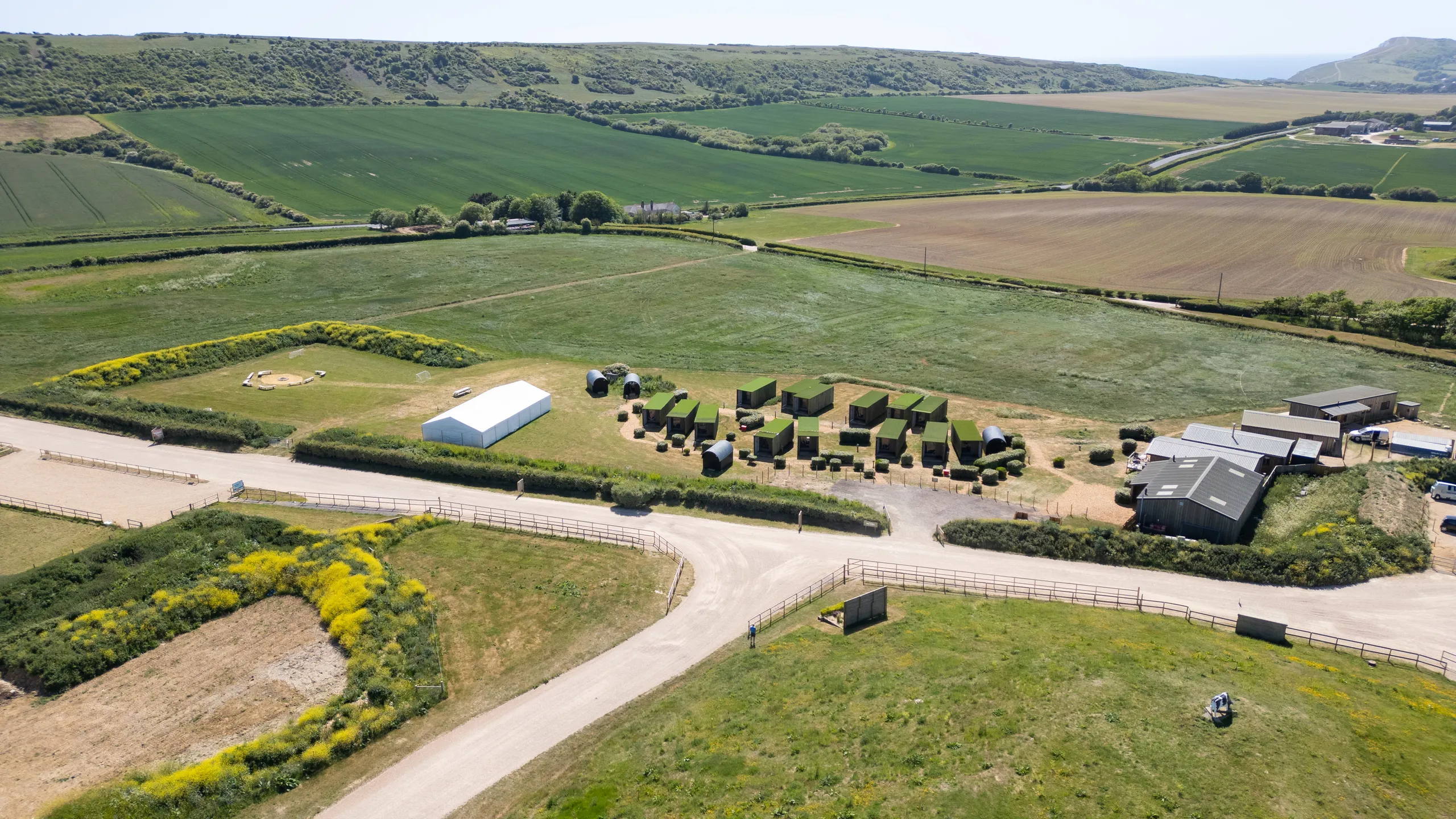 Aerial view of Camp Tapnell container accommodation and farm buildings in green countryside