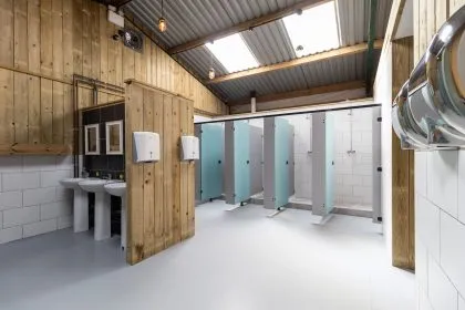 Modern glamping shower block with sinks, toilet cubicles and tiled walls