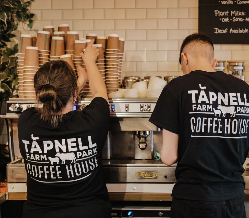 Two Tapnell Farm Park Coffee House staff members preparing drinks behind the counter
