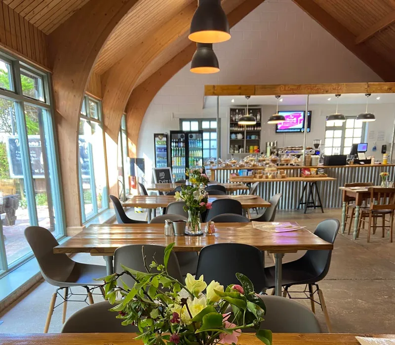 Interior of Chessell Cafe with wooden tables, flowers in a vase and a counter in the background