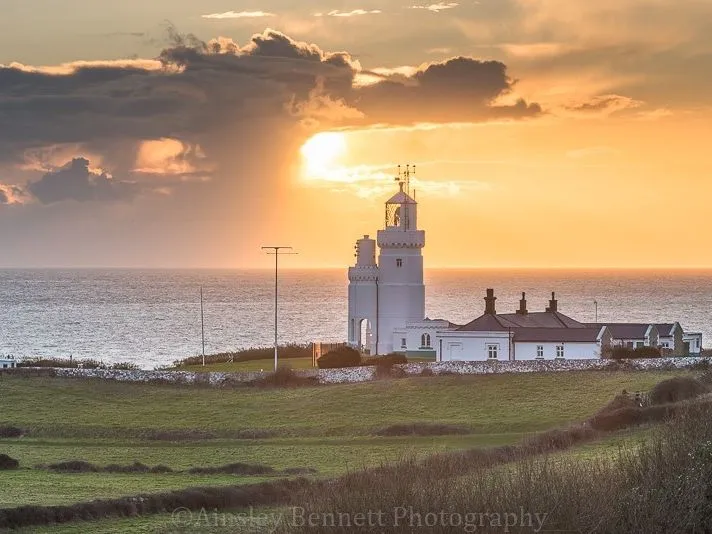 St Catherine's lighthouse and keeper's cottages at sunset overlooking the sea