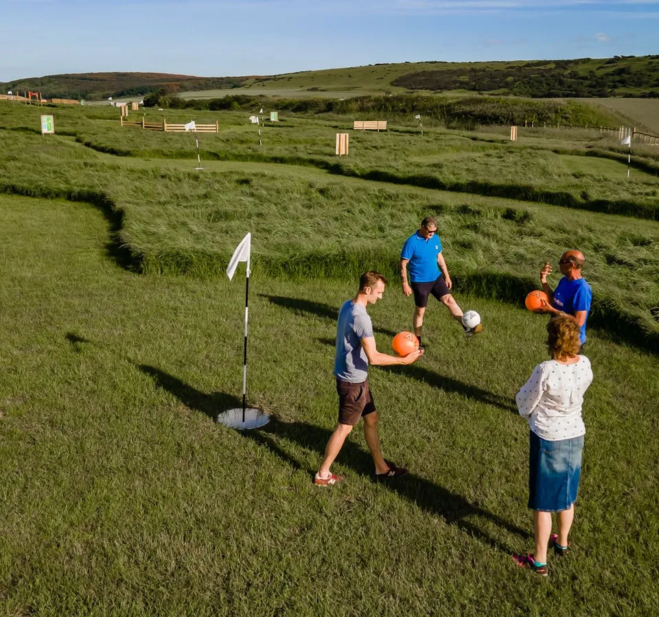 Group playing football golf on a grassy course at Tapnell Farm, Isle of Wight
