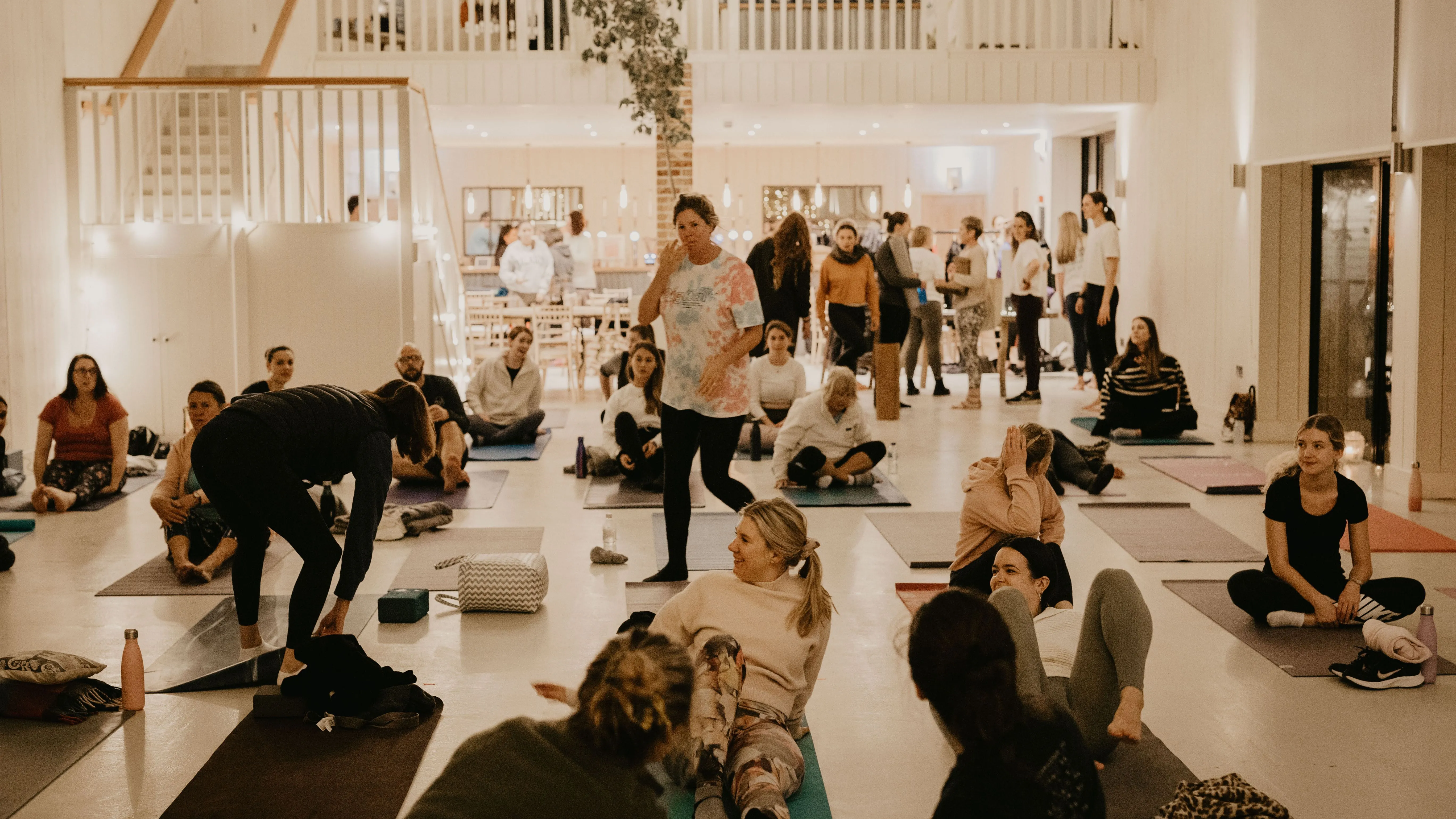 Group yoga class in a bright studio with participants on mats during a workshop