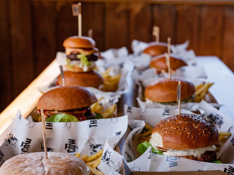 Burgers and chips served in paper-lined baskets on a long table at The Cow, Tapnell Farm, Isle of Wight
