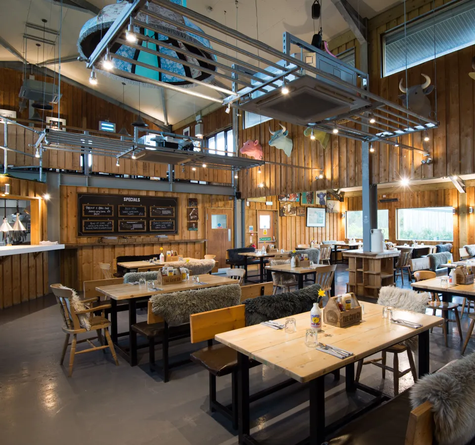 Interior of The Cow Restaurant & Bar with wooden walls, cosy seating and cow head wall sculptures